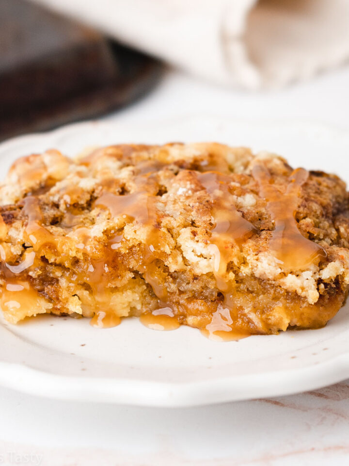 Close-up of a slice of pumpkin pie cake with cake mix on a white plate.