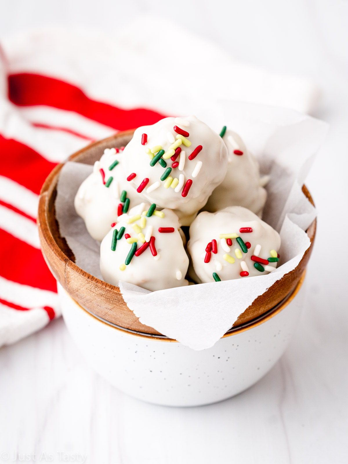 White chocolate-coated gingerbread truffles in a bowl.