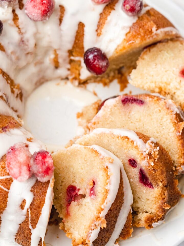 Multiple slices of a glazed cranberry orange bundt cake on a plate.